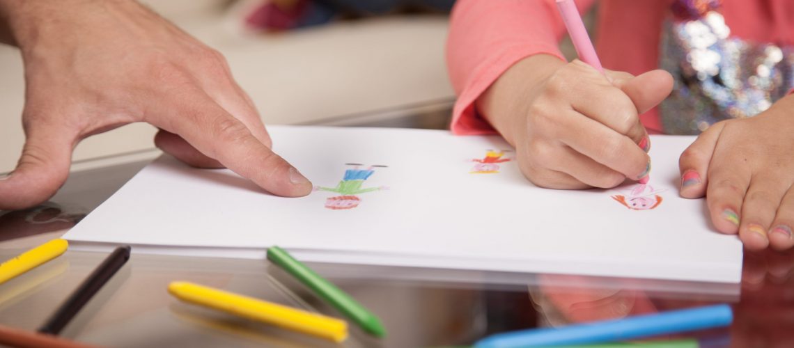 close up girl drawing her father pointing (1)